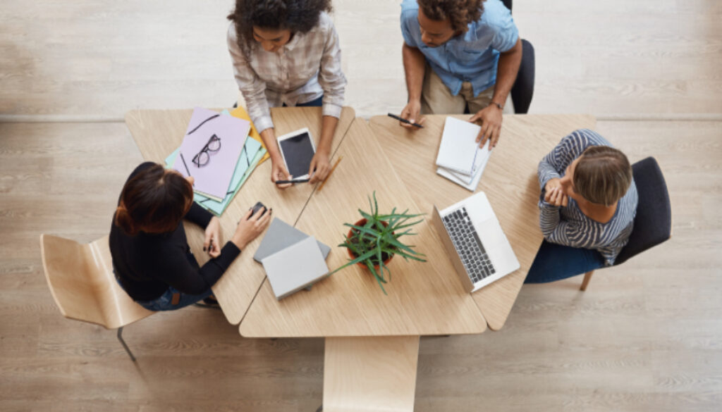 view-from-group-young-professional-entrepreneurs-sitting-table-coworking-space-discussing-profits-last-team-project-using-laptop-digital-tablet-smartphone (1)